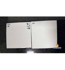 What should be done if black spots appear on enamelware made with white enamel frit?